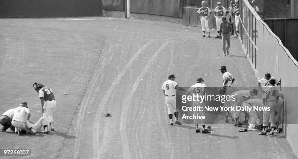 Rusty Staub, Braves' hurler Cecil Upshaw and a groundskeeper aid Don Hahn while Yogi Berra , Tug McGraw and others go to help George Theodore afte...