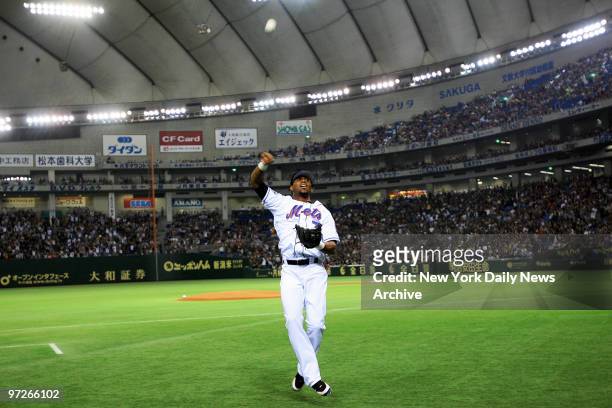New York Mets' shortstop Jose Reyes throws autographed baseballs to the crowd at the start of Game 1 of the Japan All-Star Series between the MLB...