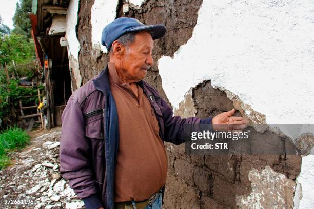 Man looks at a crack in his house affected by an earthquake on June 12 in Briceno, Narino department, Colombia. - A shallow earthquake measuring 4.3...