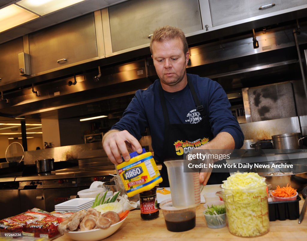 Firefighter Steve Brunner of Ladder 36, shows off pan-seared scallop