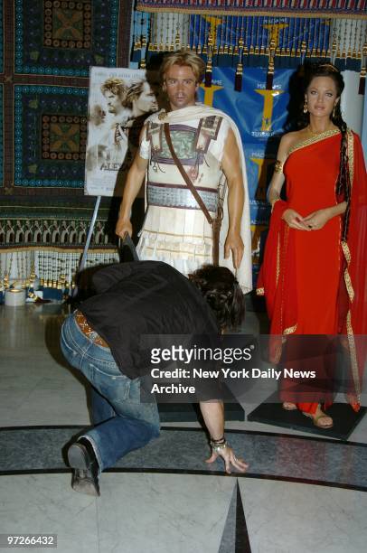 Colin Farrell bends the knee before an image of the character he plays - Alexander the Great - and Alexander's mum, played by Angelia Jolie, in the...