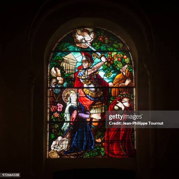 stained glass window depicting the martyrdom of saint valerie who was beheaded by her husband, monastery of st. valerie in chambon sur voueize, abbatiale sainte valérie, creuse, france - angels envy stock pictures, royalty-free photos & images
