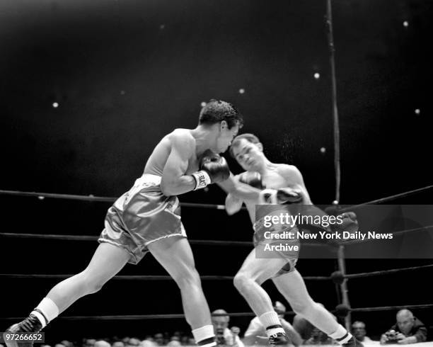 Lightweight champ Carlos Ortiz wings left hand bolo counter to head of challenger Gabriel "Flash" Elorde during last night's title bout at Madison...