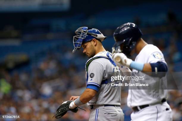 Catcher Luke Maile of the Toronto Blue Jays waits at home plate as Carlos Gomez of the Tampa Bay Rays kisses his bat on his way to face pitcher Jaime...