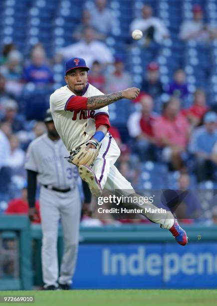 Crawford of the Philadelphia Phillies commits a throwing error after fielding a ground ball in the first inning during a game against the Colorado...