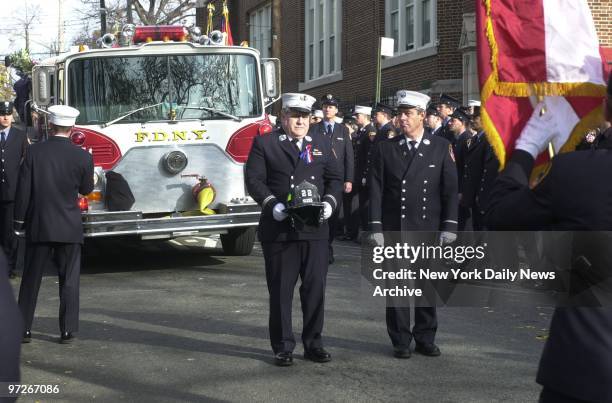 Capt. Don Striffler, holding helmet of fallen Firefighter Michael Elferis, leads funeral procession to St. Fidelis Catholic Church in College Point,...