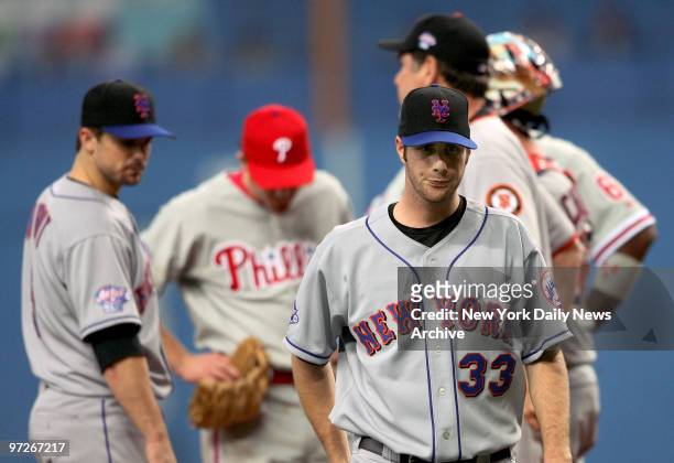 New York Mets' starter John Maine is unhappy as he walks off the mound as teammate David Wright looks on in the sixth inning of the fourth game...