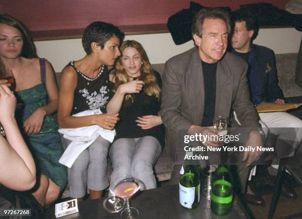 Ingrid Cesares and Madonna share a seat with Warren Beatty at party celebrating the premiere of movie "Two Girls and a Guy" at the Moomba restaurant.