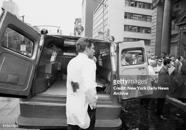 Moments after Andy Warhol was critically shot at his 33 Union Square office, his associate, Mario Amaya, walks to ambulance with back wound. Bullet...