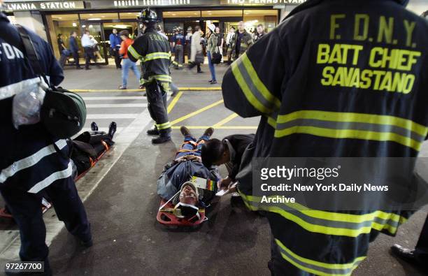 Injured passengers lie outside Penn Station awaiting removal to hospitals after a virtually empty Amtrak train rear-ended a Long Island Rail Road...