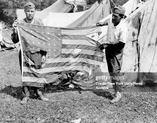 Bonus Army troops hold a tattered flag destroyed during the demonstrations in Washington, D.C.