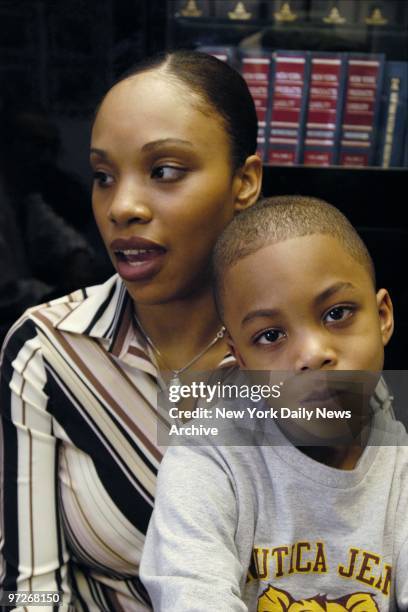 Monique Mack and her son, Taysir in their lawyer's office, where they charged that music teacher Jason Schoenberger hung the boy by his ski jacket...