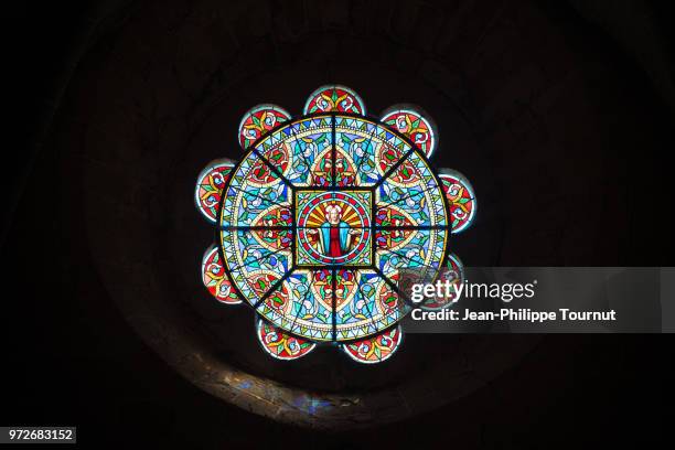 stained glass rose window with the church of "saint jacques le majeur", villefranche d'allier, allier, france - rose window stock pictures, royalty-free photos & images