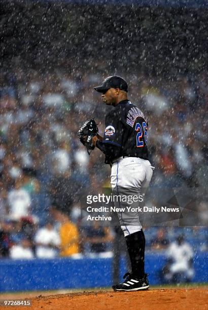 New York Mets' starter Orlando Hernandez gets drenched in a downpour in the fourth inning just before a rain delay was called during Game 1 of a...