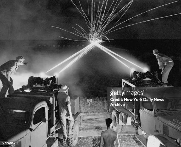 Instructors and students at the Harlingen Army Gunnery School watch the crossfire of tracer bullets from .50-caliber machine gun turrets bounce off...