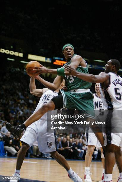 Boston Celtic' Paul Pierce drives the ball between New Jersey Nets' Richard Jefferson and Rodney Rogers during Game 1 of the Eastern Conference...