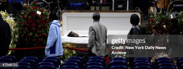 Mourners file solemnly past James Brown's body, which lies in repose inside a gold coffin, during a public viewing for the hometown legend, who was...