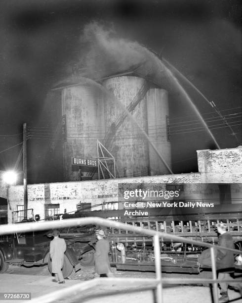 Fire at Burns Bros. At 93-08 183d St., Jamaica, Queens. Firemen pour water into burning siloes from street level. Three alarms were sounded before...