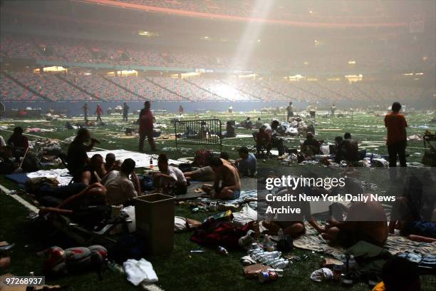 Light streaming down through the ceiling of the Superdome in New Orleans, Louisiana illuminates a ragged crowd of refugees taking shelter at the...