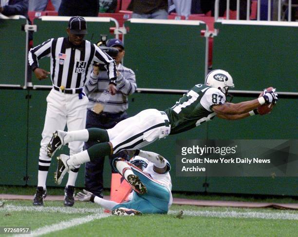 New York Jets' Laveranues Coles dives over Miami Dolphins' Sam Madison for the first of his two second-half touchdowns at Giants Stadium. He had...