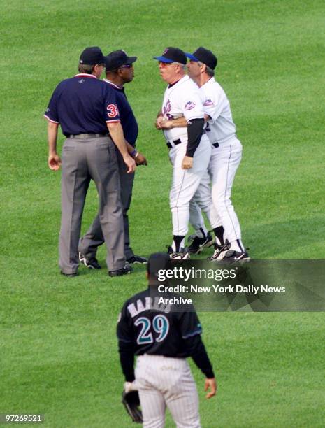 New York Mets' third base coach Cookie Rojas is restrained by manager Bobby Valentine as he argues with outfield umpire over foul ball hit by Darryl...