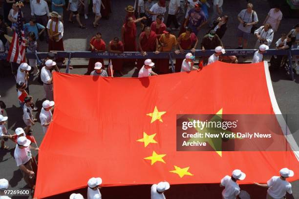 The Chinese flag is paraded past Tibetan monks on Mott St. During a rally at Confucious Square to celebrate the handing over of Hong Kong by the...