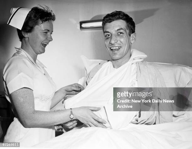 New York Rangers' forward Camille Henry and nurse Sheila O'Connor enjoy a hearty laugh at St. Clare's Hospital despite fact that Henry's left wing...