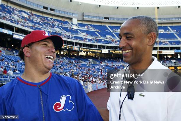 Montreal Expos' newly-acquired pitcher Bartolo Colon shares a laugh with Expos' general manager and vice president Omar Minaya during practice at...