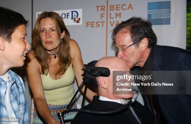 Comic Robin Williams smooches pal Christopher Reeve's head as Reeve's wife, Dana, and son Will look on before a Tribeca Film Festival screening of...