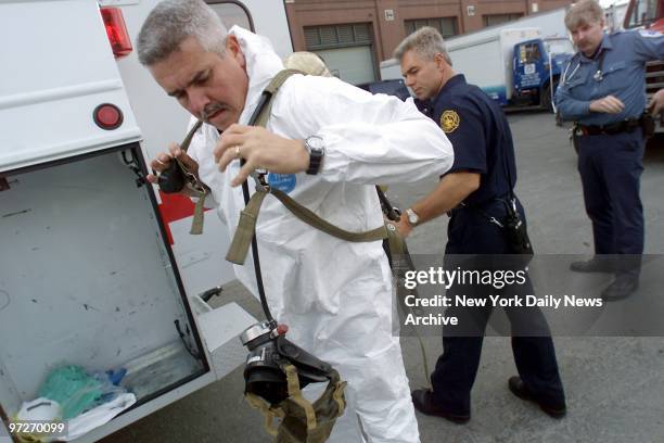 Firefighter Herman Lozado dons his hazmat suit to investigate suspicious white powder found in an envelope at the office of Jefferies, Inc., in...