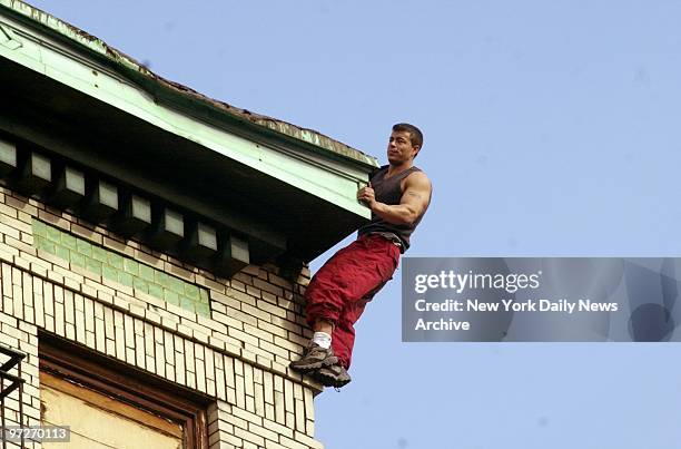 Man threatens to jump as he clings to the roof of a six-story building at 151 Delancey St. On the lower East Side. Police grabbed him before he could...
