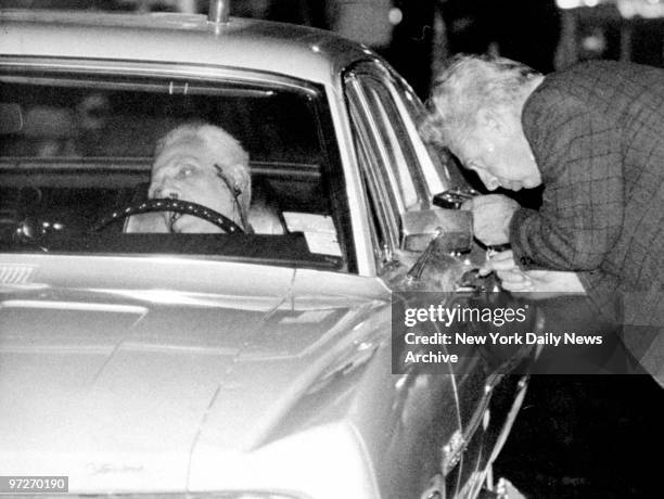 The body of Anthony Ricciardi slumps behind the wheel of his car as a policeman dusts for fingerprints in front of 84 Prospect Park.