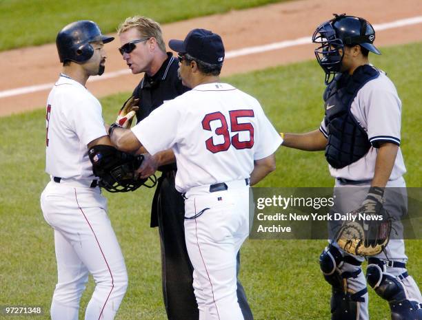 Boston Red Sox's Dave Roberts is held back by home plate umpire Jim Wolf, first base coach Lynn Jones and New York Yankees' catcher Dioner Navarro...