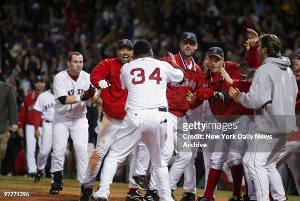 Boston Red Sox's David Ortiz is greeted at the plate by teammates after hitting a game-winning, two-run homer in the 12th inning of the American...