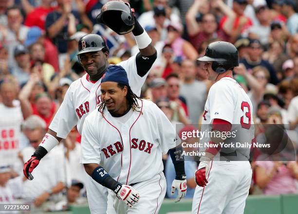 Boston Red Sox's David Ortiz and Mark Loretta celebrate with Manny Ramirez after all three scored on Ramirez' three-run homer to left field in the...