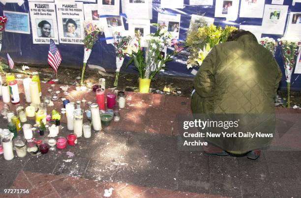 Mourner grieves in front of the makeshift memorial site, dubbed the Wall of Prayers, which has sprung up in front of Bellevue Hospital on First Ave....