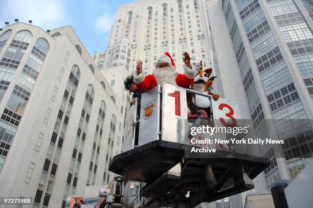 Firefighters come to the aid of Santa Claus by lifting him up by cherry picker as he pays his annual visit to children at New York-Presbyterian/Weill...