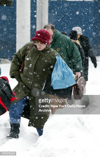 Commuters negotiate a slippery path as they leave the Staten Island ferry terminal amid a flurry of flakes on the morning after the Blizzard of '03...