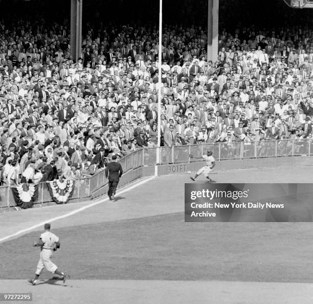 Sandy Amoros goes racing into left field corner to make a scintillating, one-hand grab of Yogi Berra's bid for an extra base hit in the sixth inning...