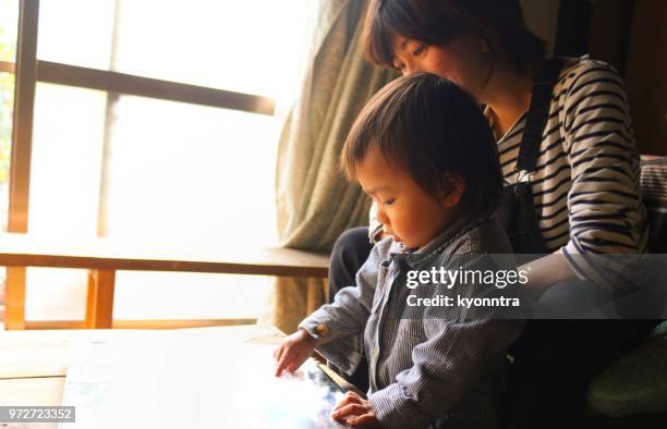 mother and son is making photo albam - kyonntra stock pictures, royalty-free photos & images