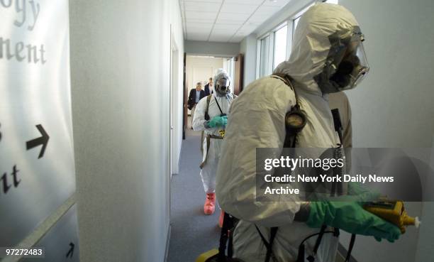 Firefighters in hazmat suits enter offices of Jefferies, Inc., in Jersey City, N.J., to investigate suspicious white powder found in an envelope.