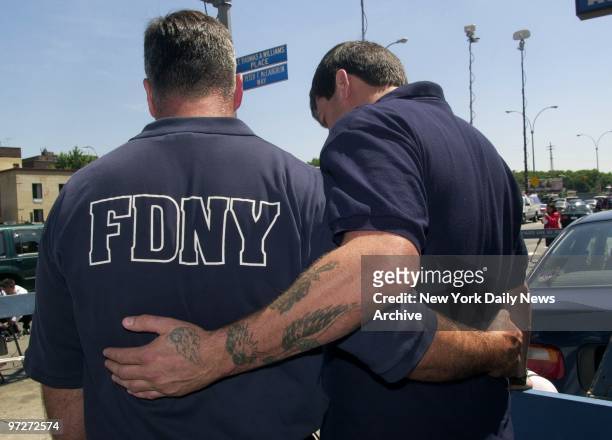 Firefighters John Gaine and Mark McKay comfort each other as they mourned lost colleagues outside Rescue Co. 4 in Queens. Firefighters Harry Ford and...
