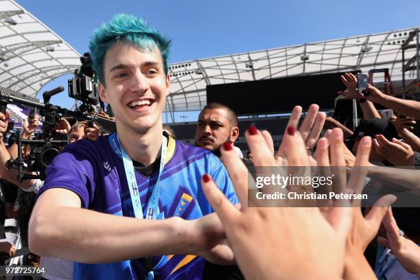 Gamer 'Ninja' high fives fans as he arrives to the Epic Games Fortnite E3 Tournament at the Banc of California Stadium on June 12, 2018 in Los...