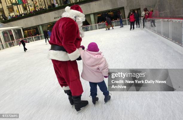 Santa Claus - always a good skate - lends a hand as Chloe Isaac, a 6-year-old Londoner, negotiates the Rockefeller Center ice skating rink.