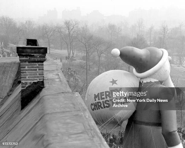 Santa Claus climbs down Central Park West while one of chimneys he'll come down Christmas Eve, stands in foreground. If you think Santa is too fat to...