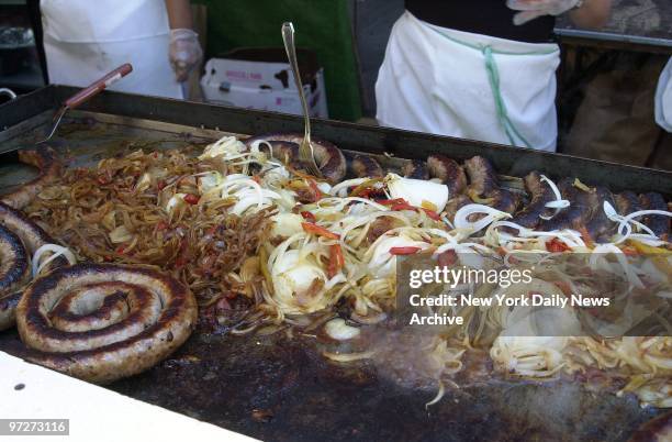 Sausages and onions are sizzling in preparation for hungry strollers at the 75th annual Feast of San Gennaro. The 11-day celebration in Little Italy...