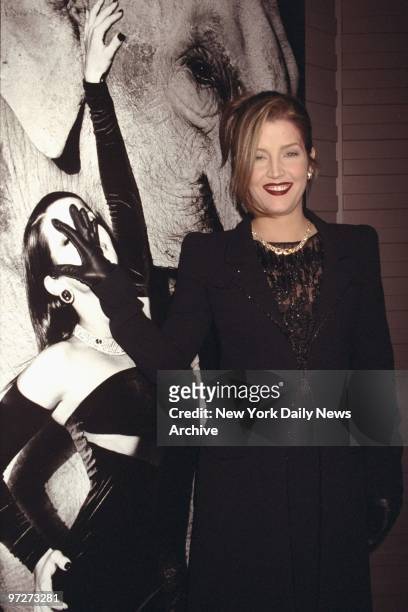 Lisa Marie Presley covers her face on a picture of herself posing with an elephant that appears in "Untamed", a photographic book by Cartier on the...