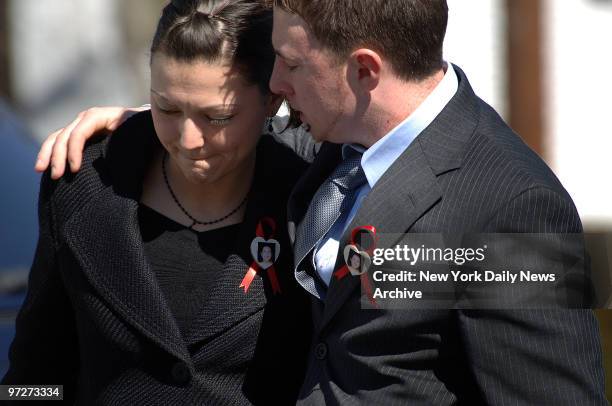 Mourners wearing buttons bearing the photograph of Imette St. Guillen console one another after a funeral service for the slain 24-year-old graduate...