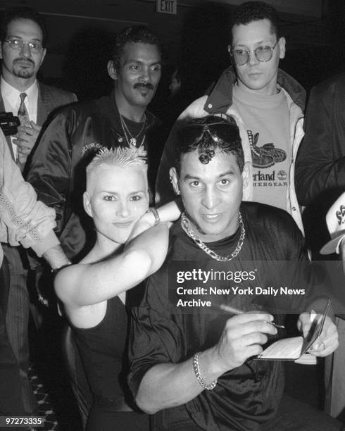 Boxer Hector "Macho" Camacho sits on Susan Powter's laps as he signs autographs at Vinny Pazienza's victory party at Bally's.