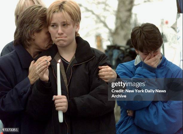 Mourners weep at vigil for victims outside Columbine High School in Littleton, Colo., where two teenagers shot to death 12 students and a teacher...